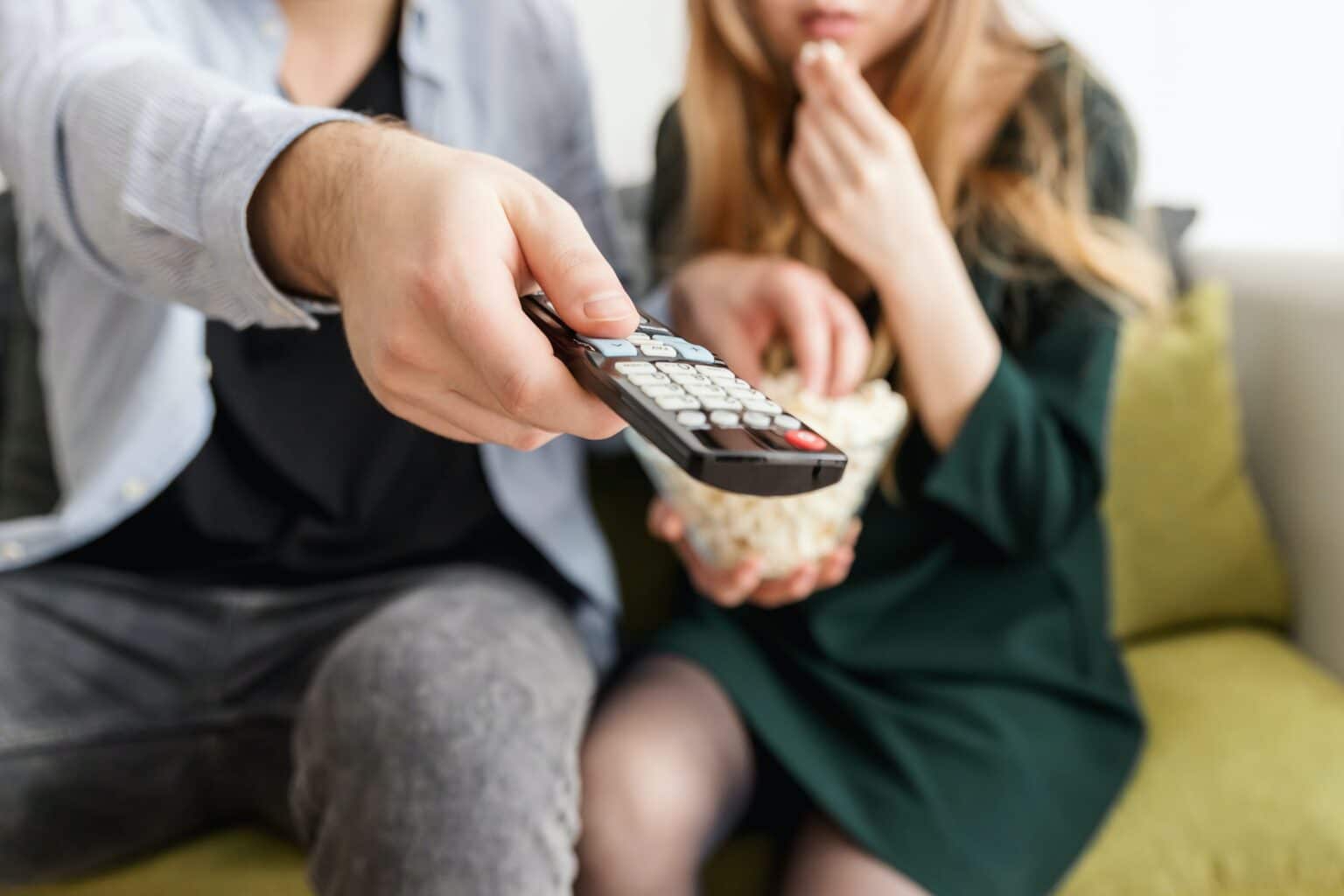 Couple sitting on the couch watching TV.