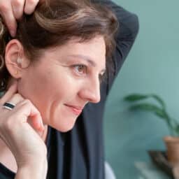 Woman adjusts hearing aid