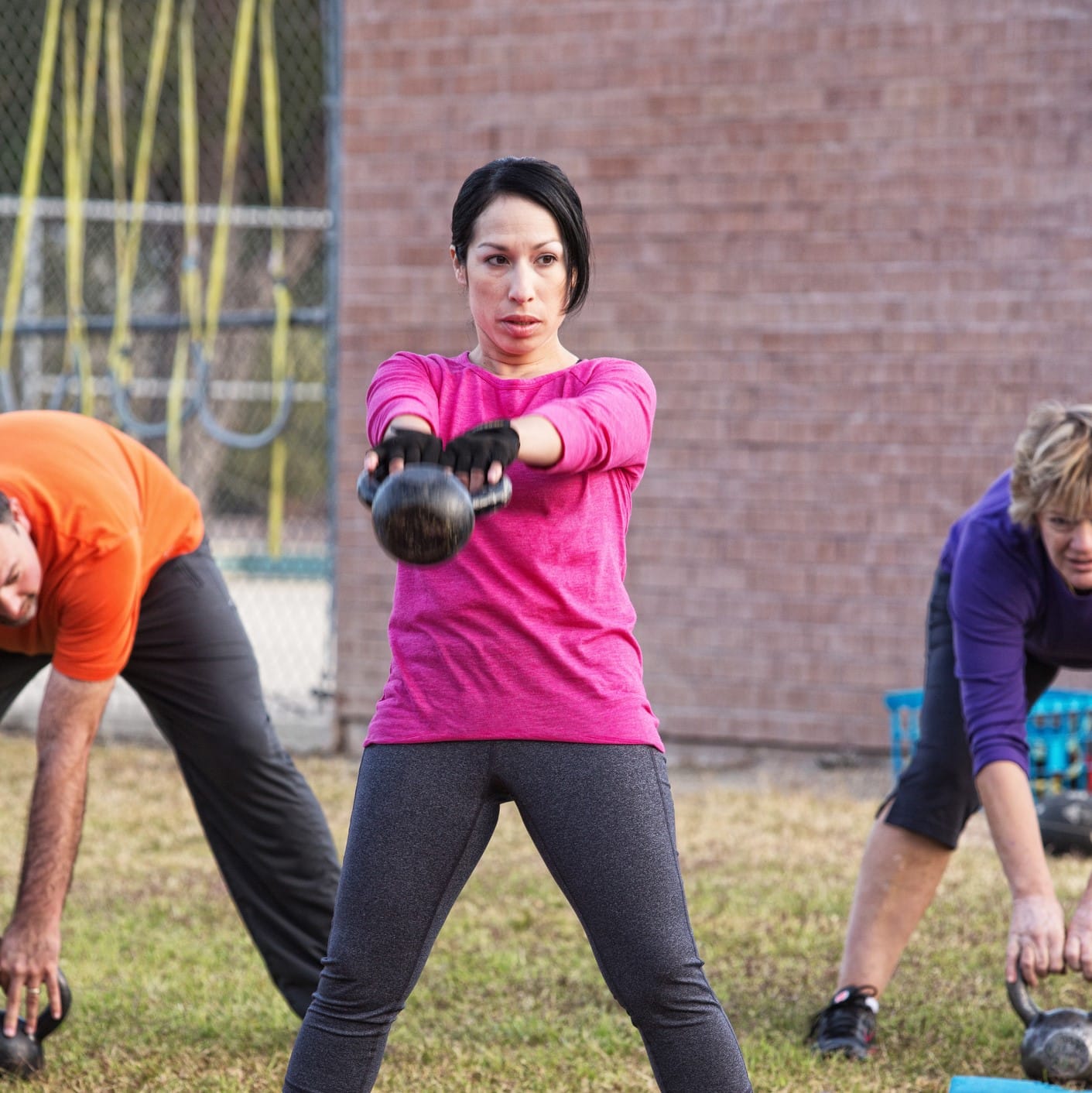 Woman working out with a group outside.