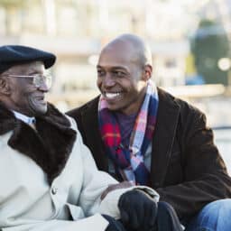 Father and son having a nice conversation in a park on a winter day.